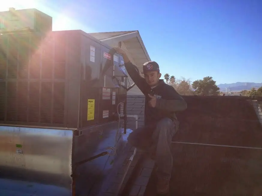 HVAC technician performing Heat Pump Repair on a rooftop unit in California Polytechnic State University